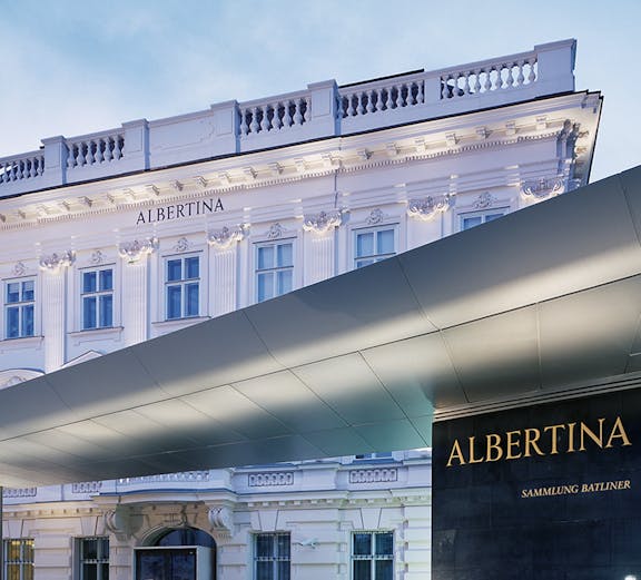 Albertina Museum entrance with illuminated facade in Vienna.