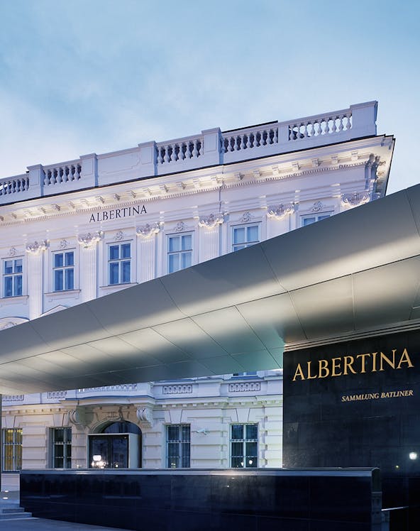 Albertina Museum entrance with illuminated facade in Vienna.