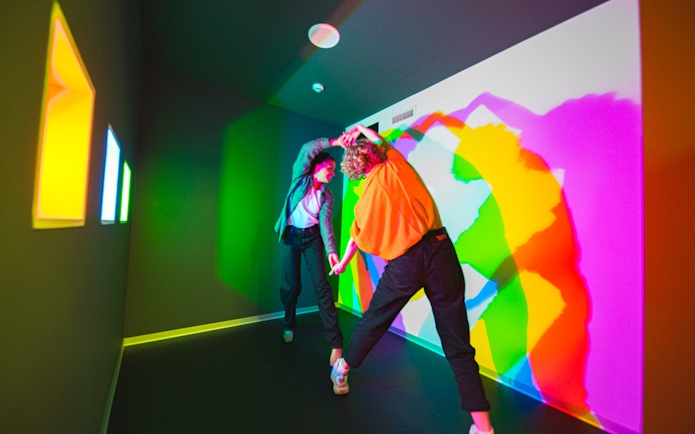 Visitors interacting with colorful light display at Paradox Museum, Stockholm.