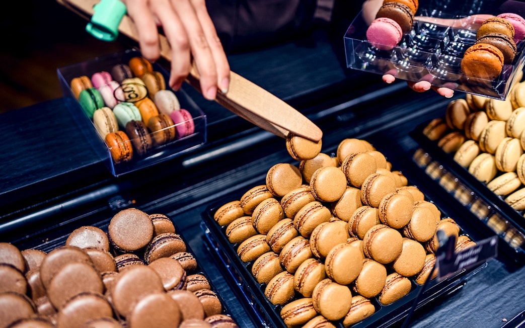 Macarons being selected during a Secret Food Tour near Notre Dame, Paris.