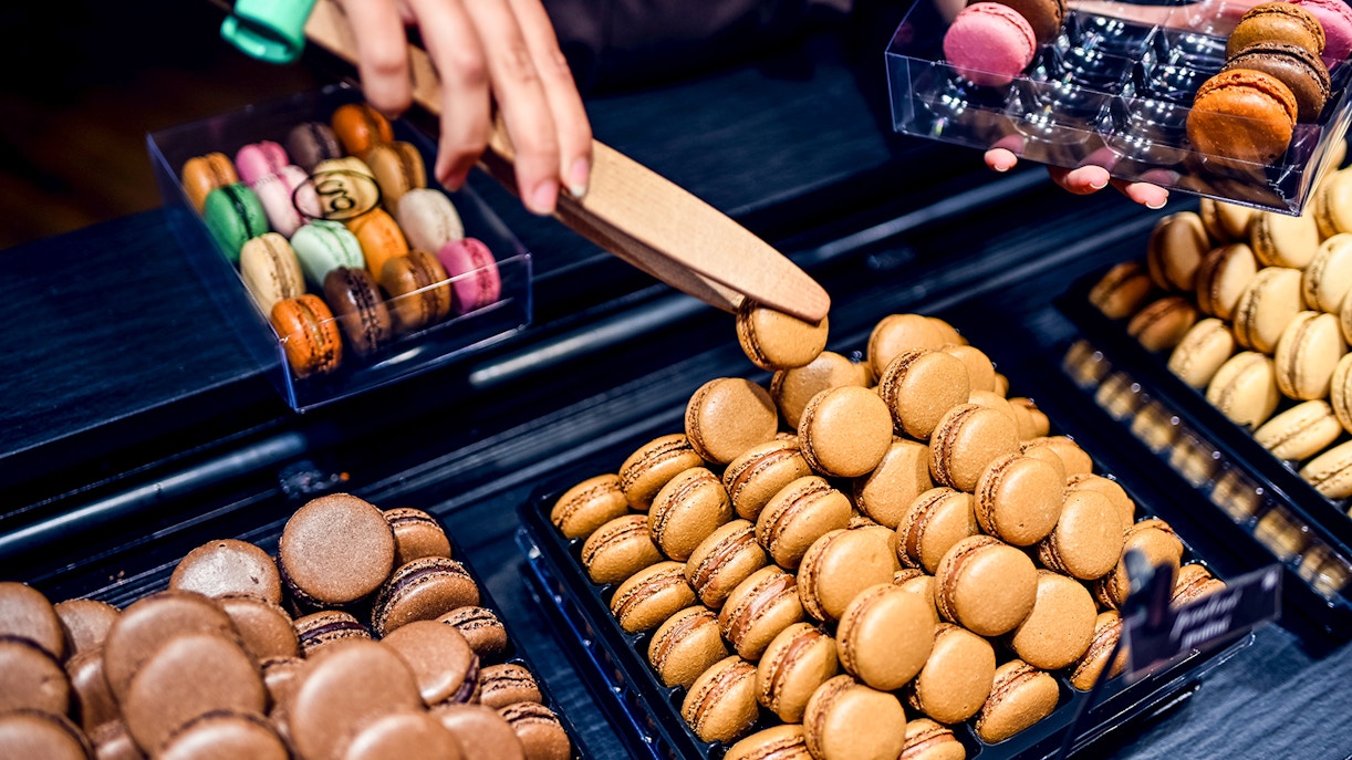 Macarons being selected during a Secret Food Tour near Notre Dame, Paris.