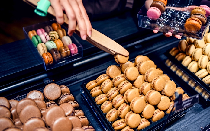 Macarons being selected during a Secret Food Tour near Notre Dame, Paris.