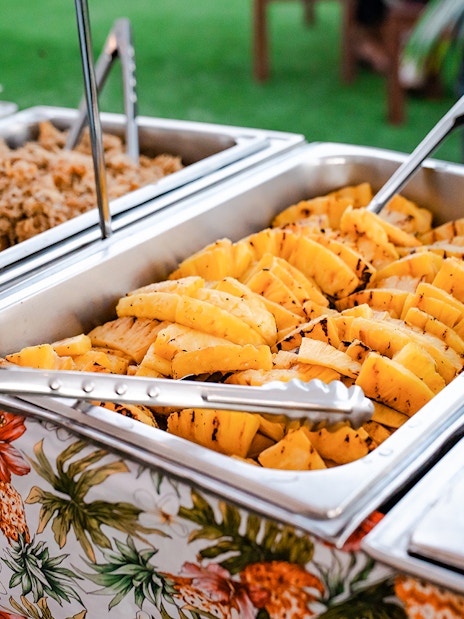 Buffet with grilled pineapple and pulled pork at Mauka Warriors Luau.