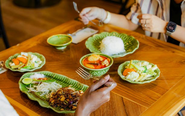 Thai meal with curry, rice, and vegetables served on green plates at Khao Lak dining experience.