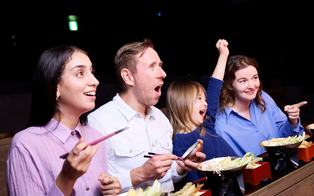 People enjoying a Japanese dining experience with a live show.