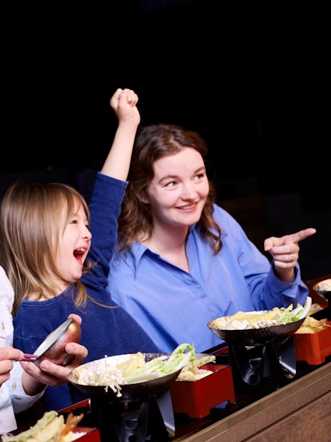 People enjoying a Japanese dining experience with a live show.