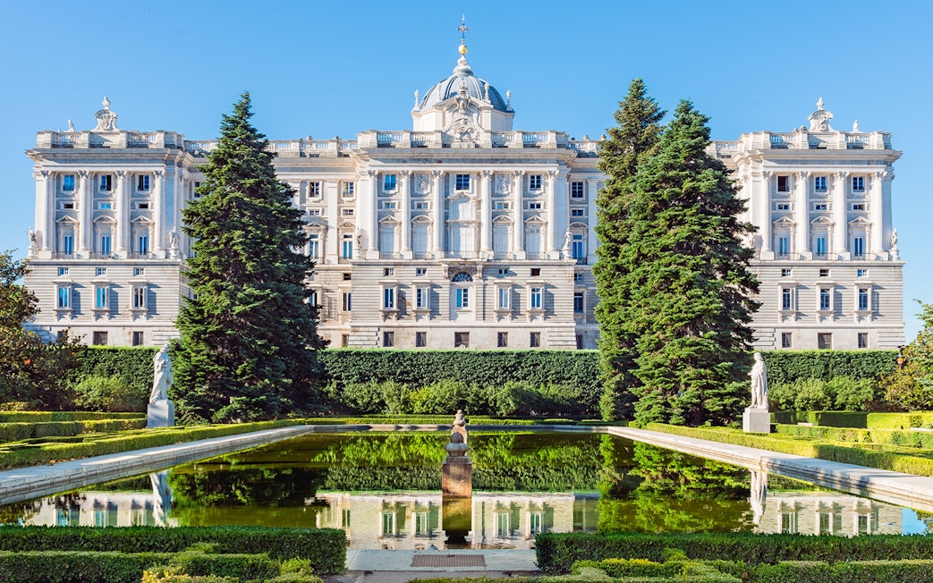 Royal Palace of Madrid with garden and reflecting pool in foreground.