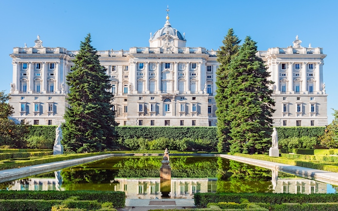Royal Palace of Madrid with garden and reflecting pool in foreground.