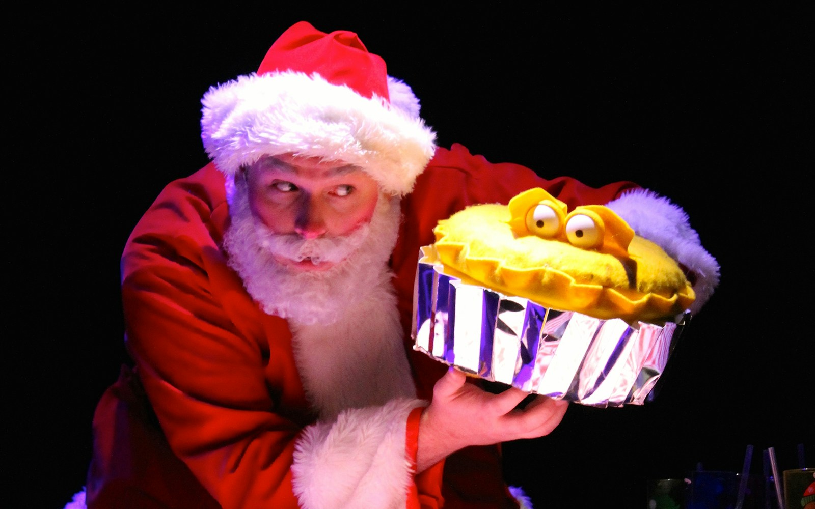 Father Christmas in a festive setting, holding a list, part of the "Father Christmas Needs a Wee!" tour in London.