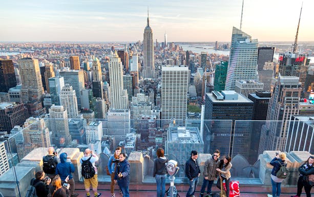 Visitors on Top of the Rock with Empire State Building view, New York City.