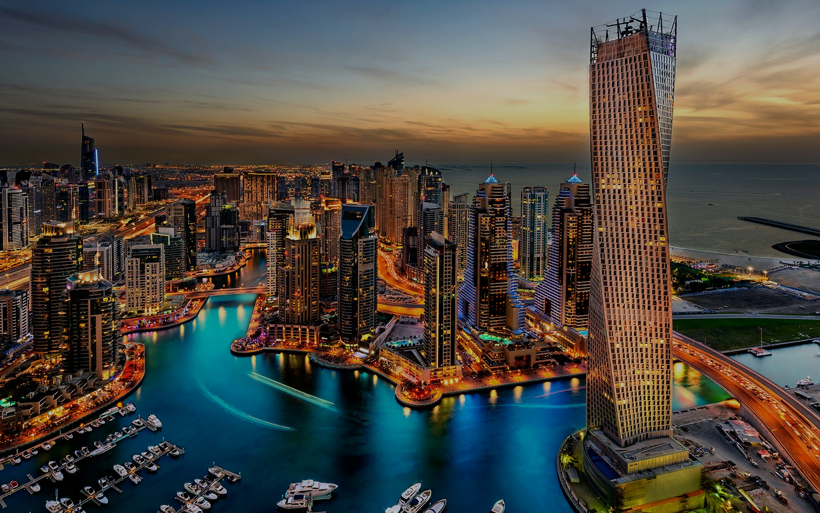 Dubai Creek skyline at sunset with illuminated skyscrapers and boats, highlighting New Year Cruise Party.