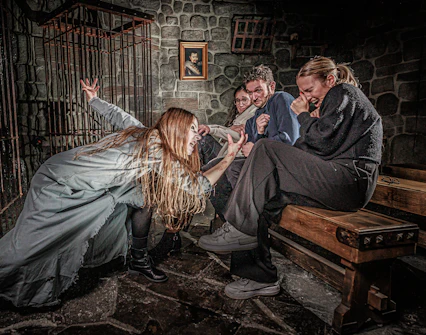 Visitors react to a performer in a spooky scene at the London Dungeon.