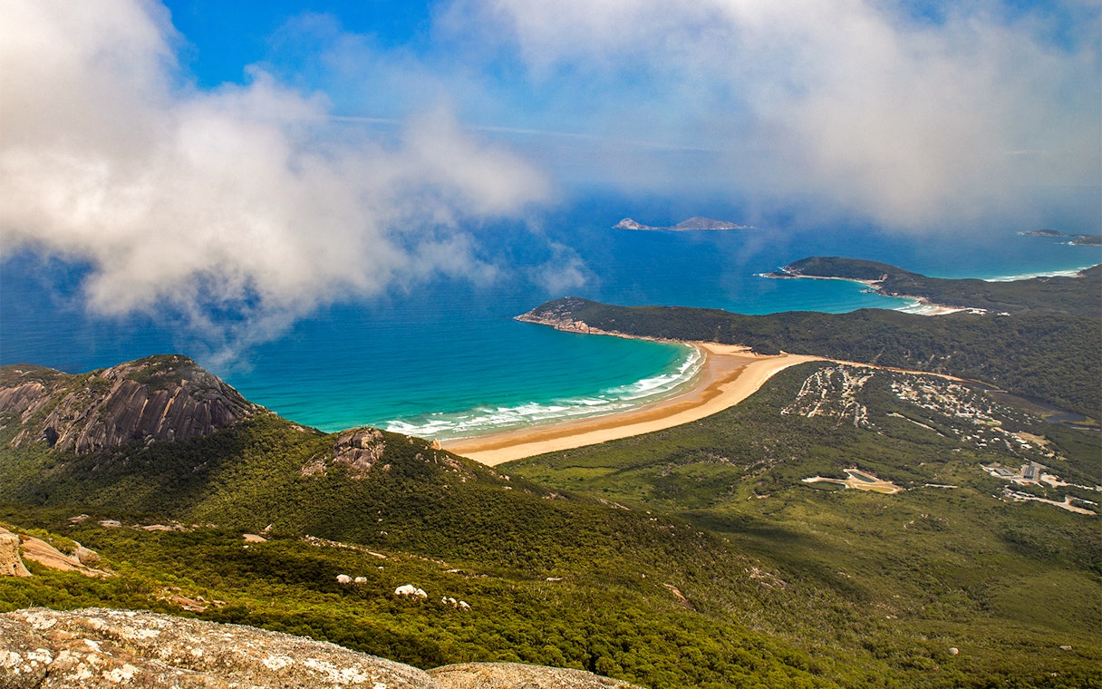 Aerial view of Wilsons Promontory coastline with lush greenery and turquoise ocean.