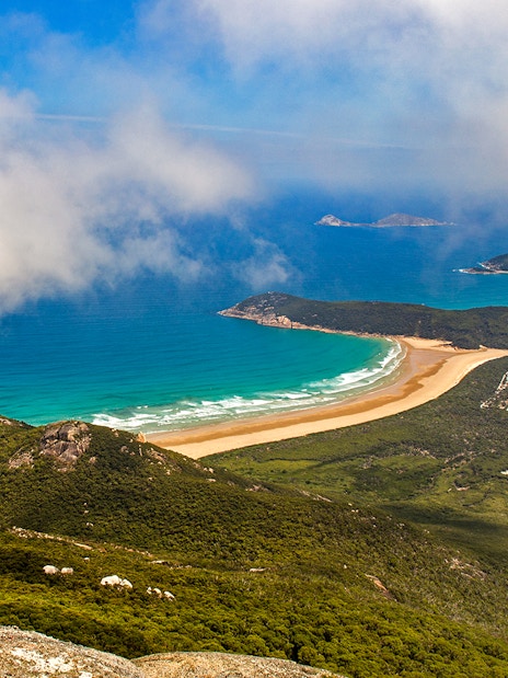 Aerial view of Wilsons Promontory coastline with lush greenery and turquoise ocean.