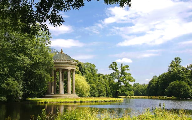Nymphenburg Palace garden with temple by a lake in Munich, Germany.