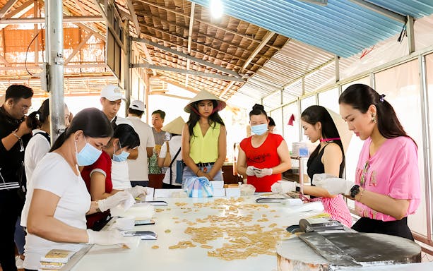 People making traditional snacks on Mekong Delta day tour from Ho Chi Minh.