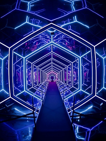 Futuristic neon-lit tunnel at AMAZE Amsterdam experience.