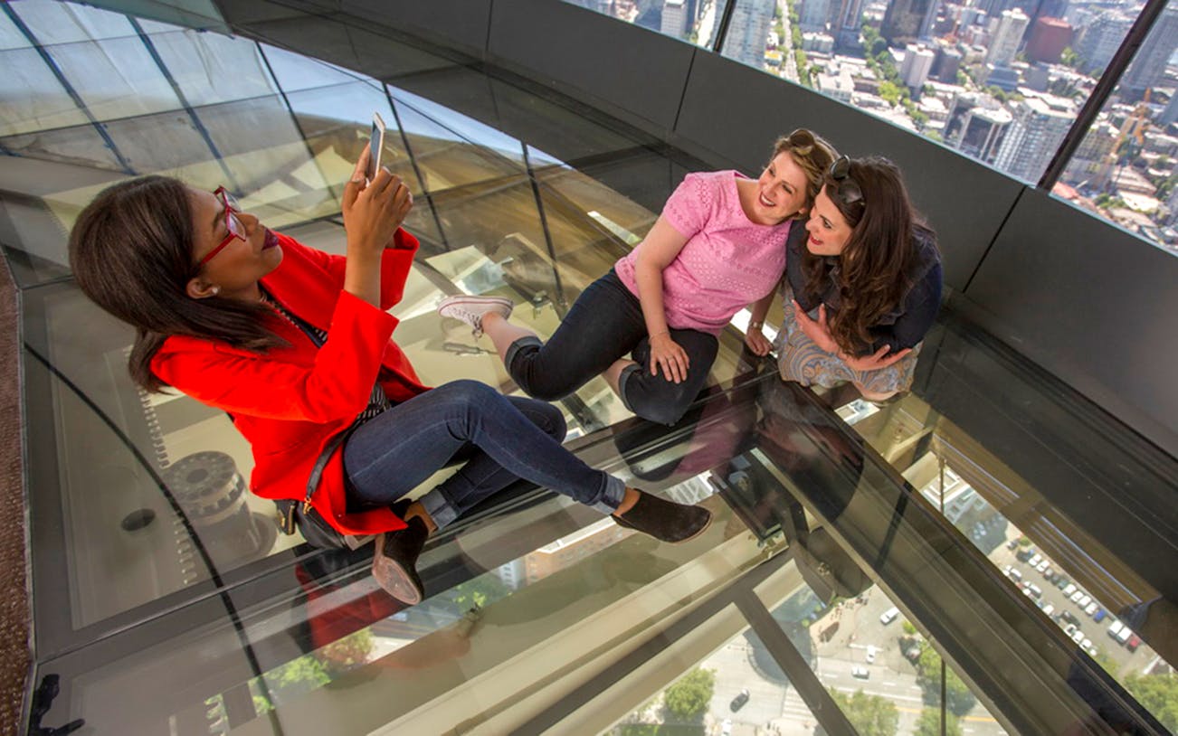 Visitors enjoying the glass floor at Seattle Space Needle, part of Seattle CityPASS®.