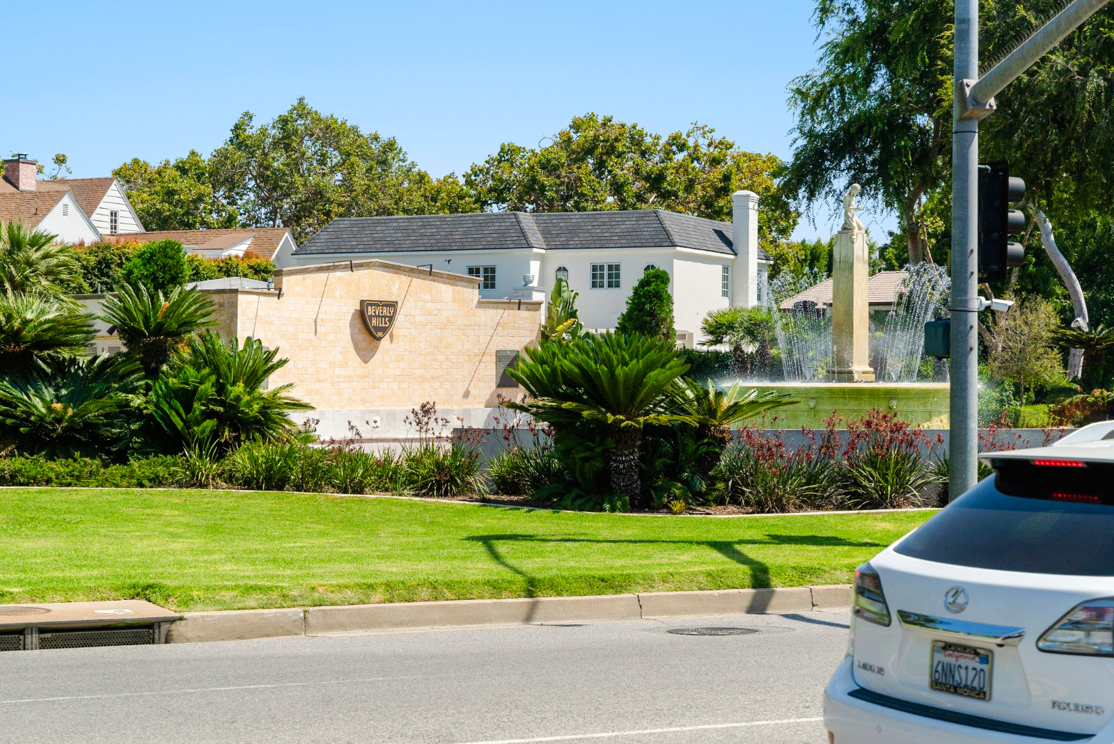 Electric Fountain at Beverly Gardens Park, Beverly Hills, with surrounding greenery and nearby homes.