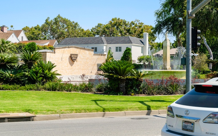 Electric Fountain at Beverly Gardens Park, Beverly Hills, with surrounding greenery and nearby homes.