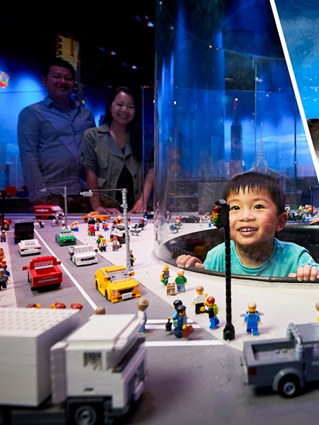 Child exploring LEGO city display and penguins at SEA LIFE Melbourne.