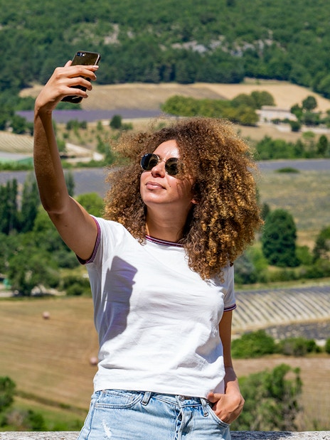 Person taking a selfie with lavender fields in Sault, France in the background.