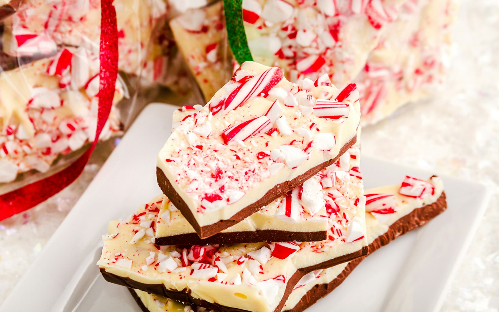 Peppermint bark with crushed candy canes on a white plate.