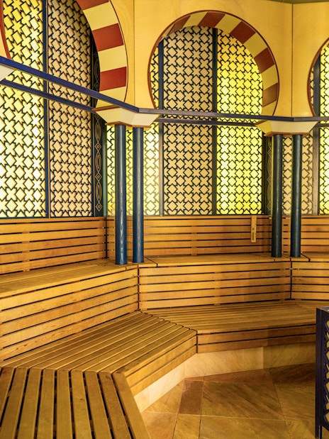 Therme Bucuresti sauna interior with wooden benches and decorative walls.