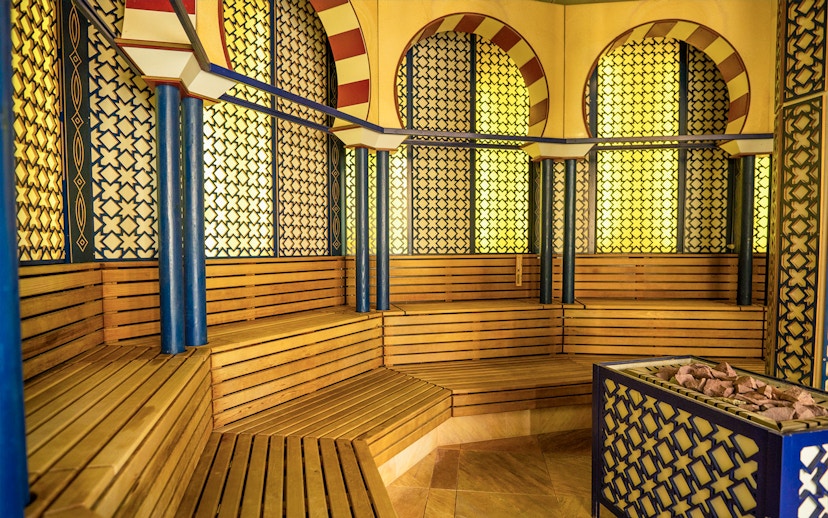 Therme Bucuresti sauna interior with wooden benches and decorative walls.