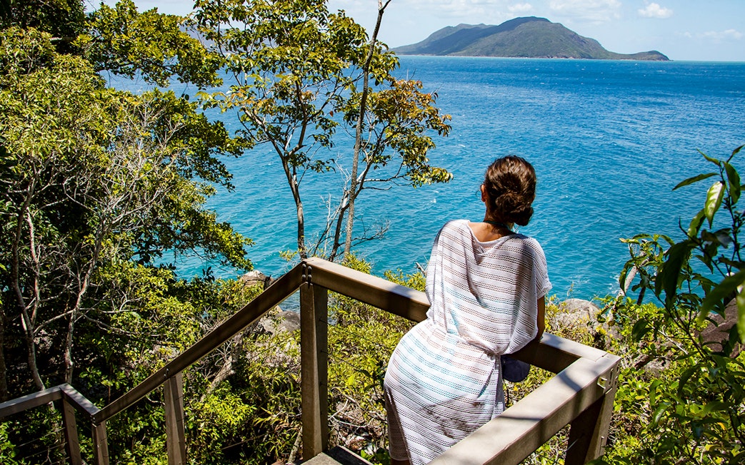 Visitor overlooking ocean view from Fitzroy Island trail.
