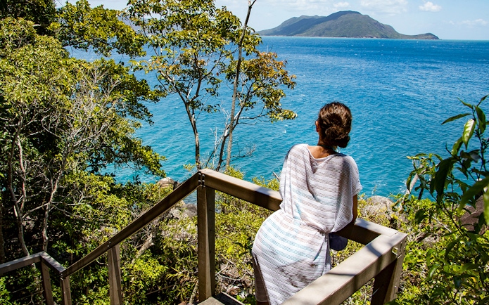 Visitor overlooking ocean view from Fitzroy Island trail.