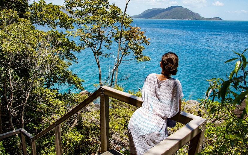 Visitor overlooking ocean view from Fitzroy Island trail.