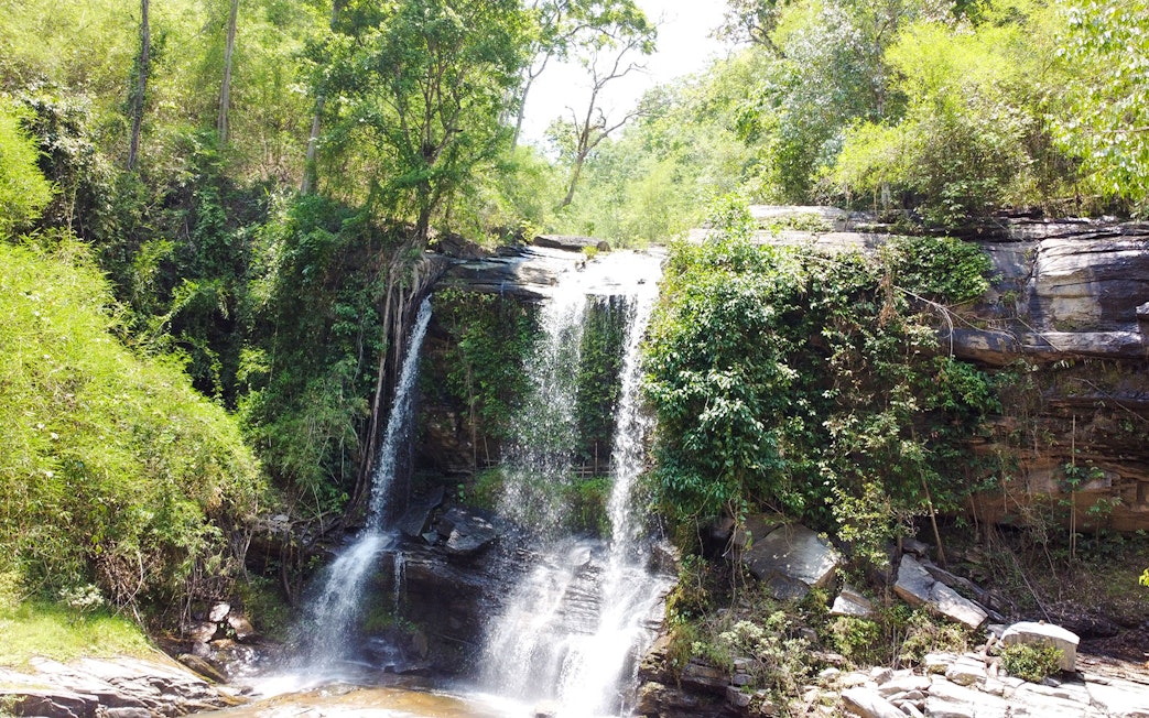Waterfall surrounded by lush greenery in Chiang Mai, Thailand.