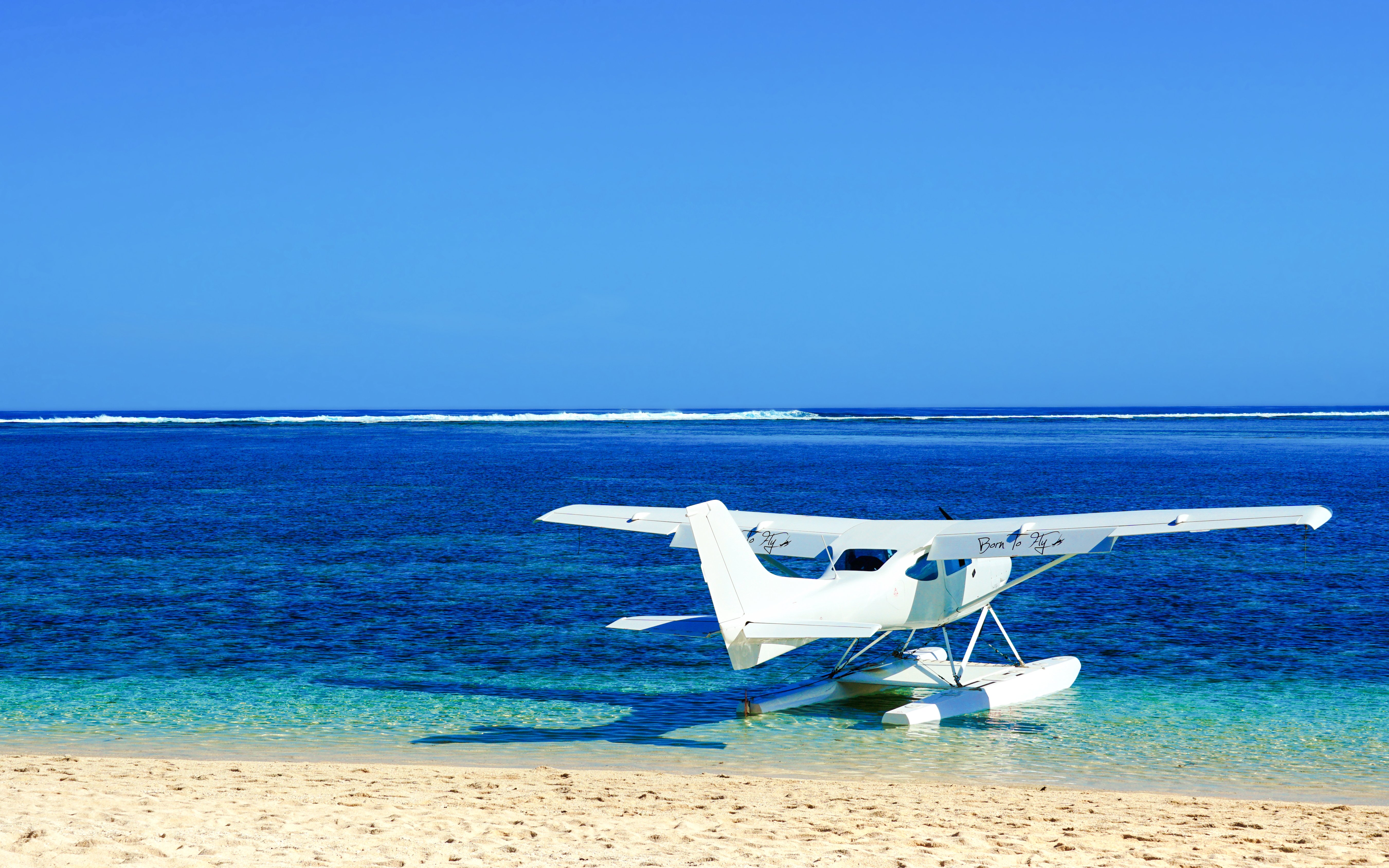 Seaplane on the shore of Mauritius with clear blue ocean.