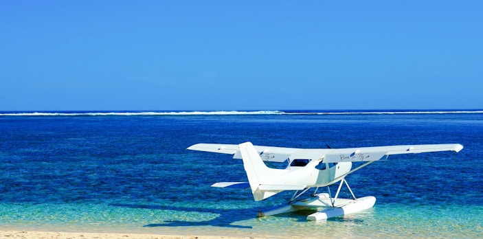 Seaplane on the shore of Mauritius with clear blue ocean.