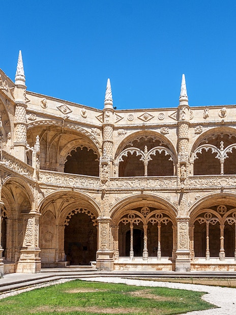Monastery of Jeronimos Cloister entrance with ornate arches, Lisbon, Portugal.