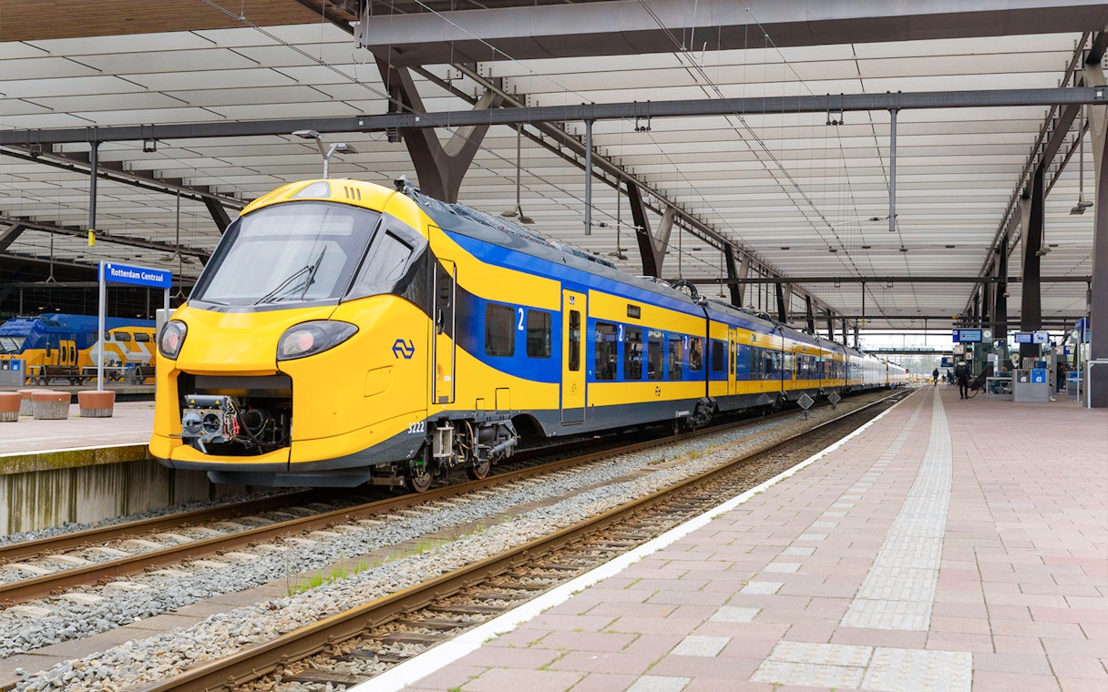 NS train at platform in Rotterdam Central Station for Schiphol Airport to Amsterdam transfer.