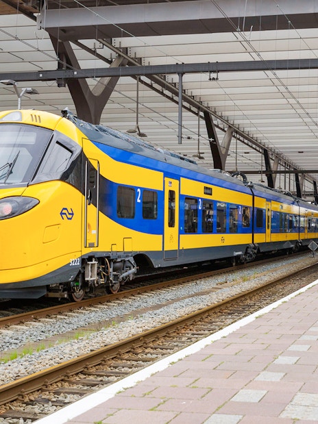 NS train at platform in Rotterdam Central Station for Schiphol Airport to Amsterdam transfer.