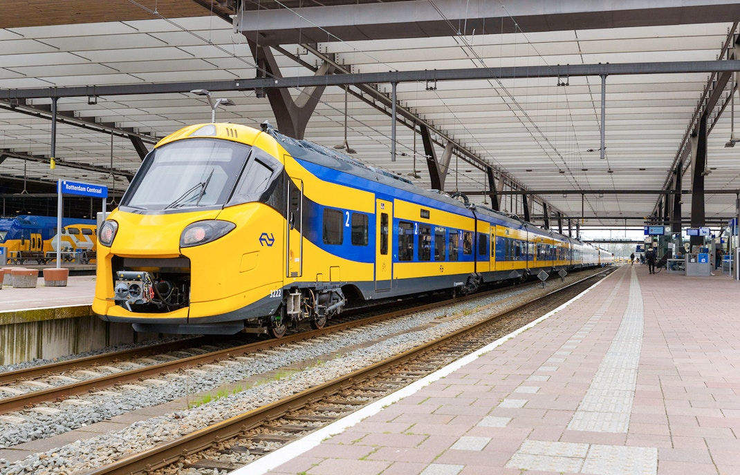 NS train at platform in Rotterdam Central Station for Schiphol Airport to Amsterdam transfer.