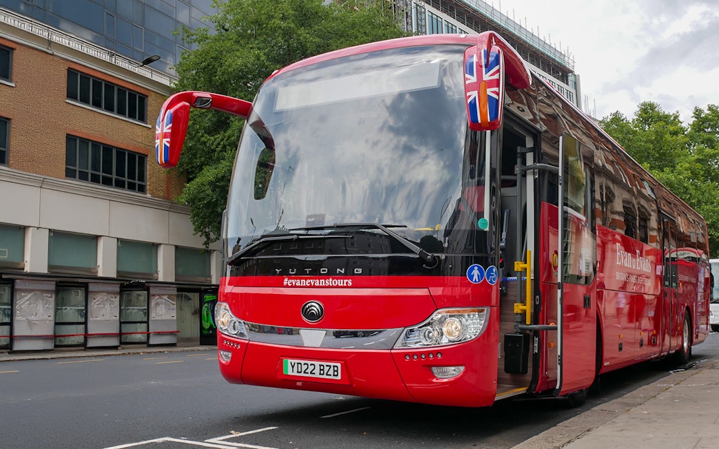 Stonehenge, Windsor Castle, and Bath day trip coach parked near London street.