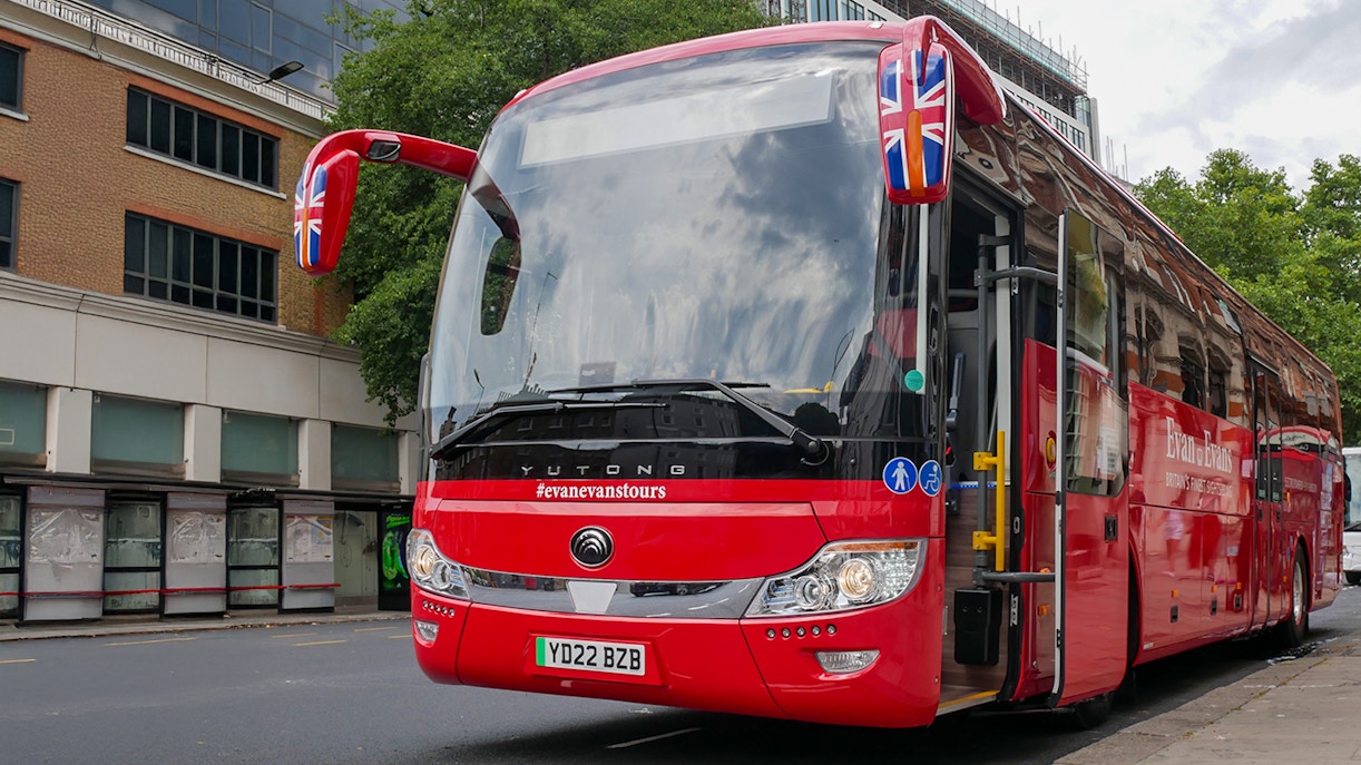 Stonehenge, Windsor Castle, and Bath day trip coach parked near London street.