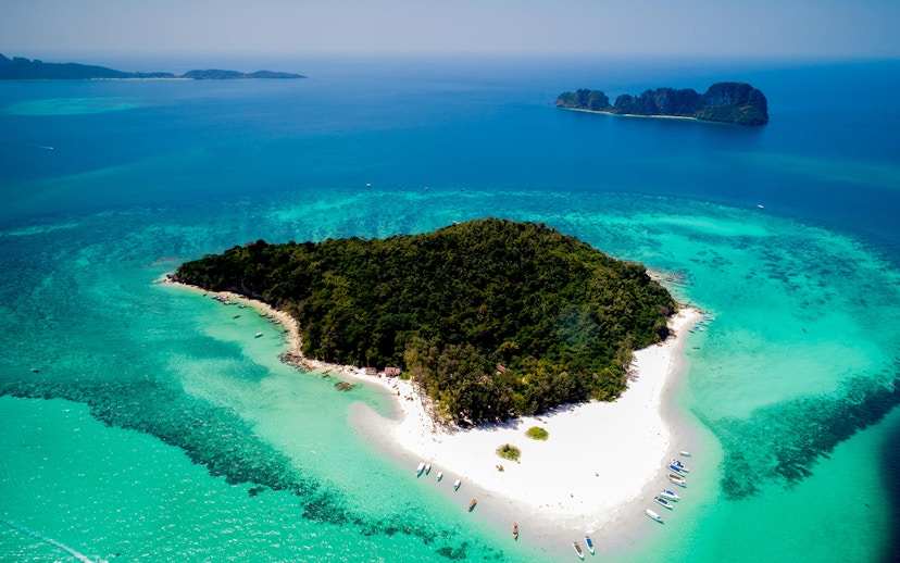 Aerial view of Bamboo Island's lush greenery and white sandy beaches in Thailand.