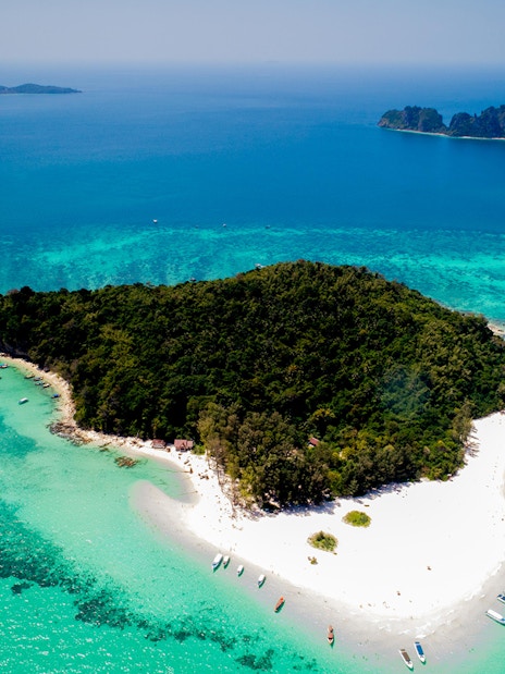 Aerial view of Bamboo Island's lush greenery and white sandy beaches in Thailand.