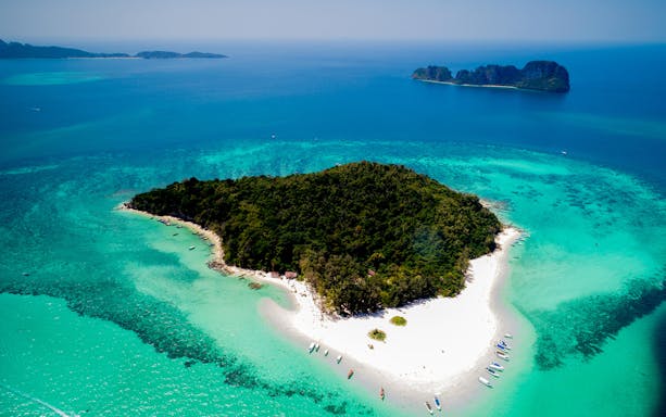 Aerial view of Bamboo Island's lush greenery and white sandy beaches in Thailand.