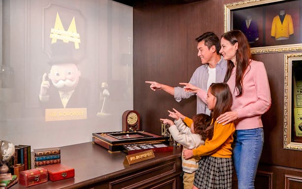 Family interacting with Mr. Monopoly hologram at Monopoly Dreams Melbourne.