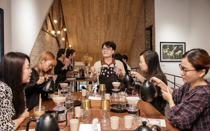 Participants brewing coffee in a Vietnamese coffee workshop.