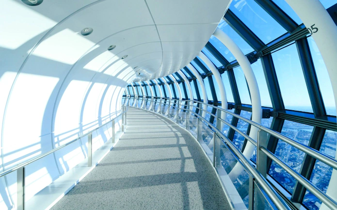 Curved glass corridor at Tokyo Skytree tembo deck with city view.