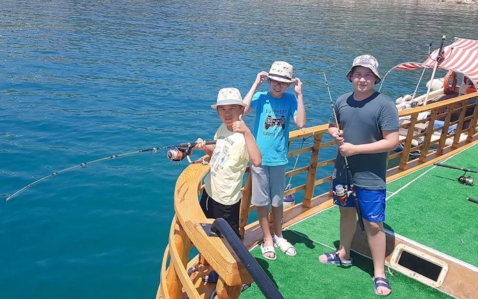 Children fishing on a boat deck during Alanya Relaxing Boat Tour.