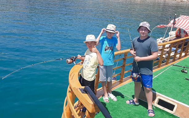 Children fishing on a boat deck during Alanya Relaxing Boat Tour.