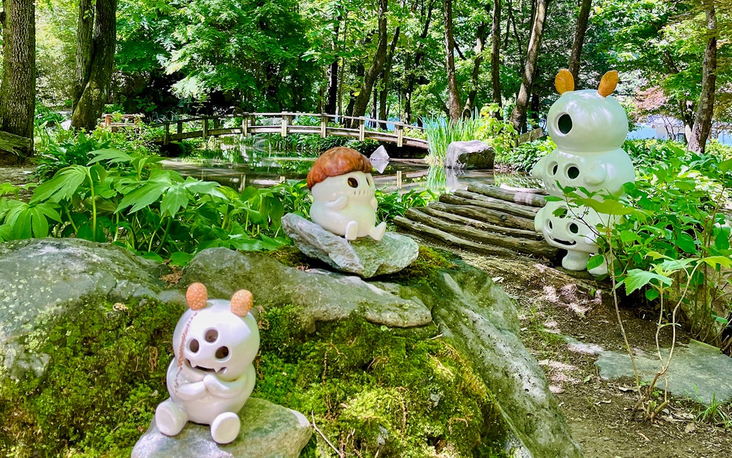 Ceramic figures among bamboo groves and a wooden bridge in Nami Island, South Korea.
